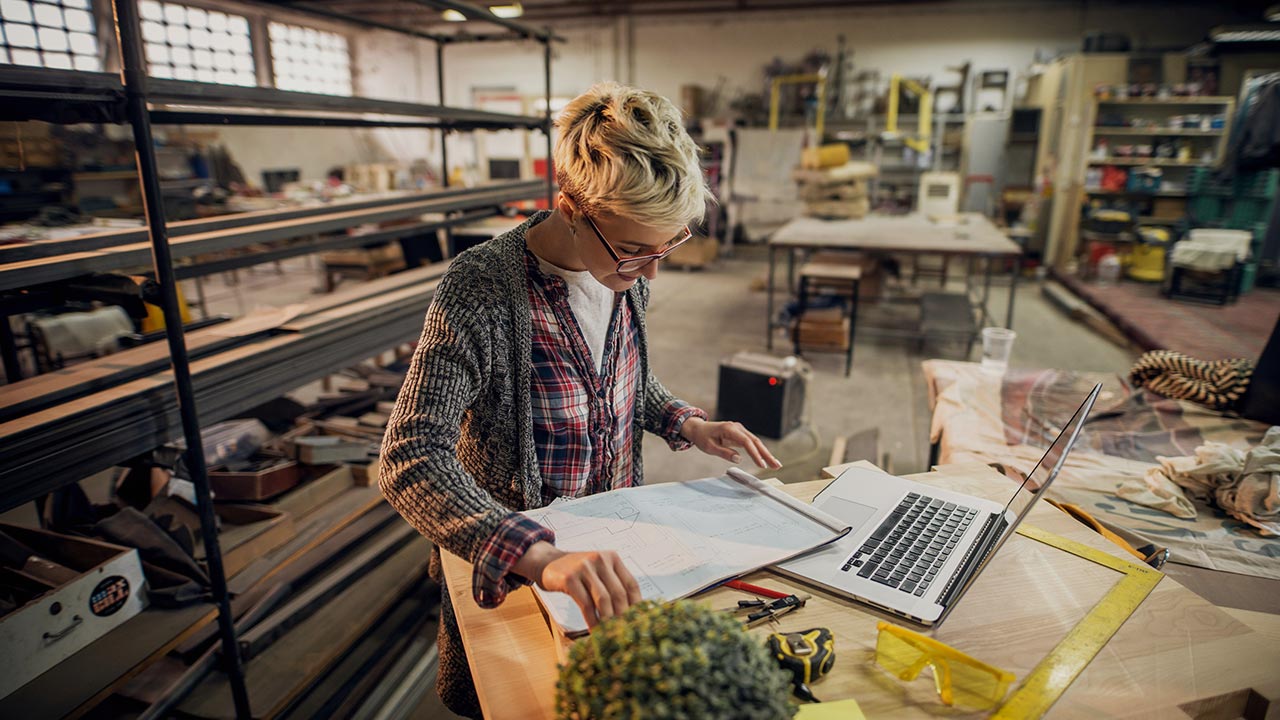 Frau in einer Werkstatt mit Laptop © Unsplash+